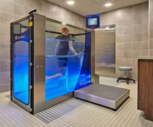 Physical therapist demonstrating HydroWorx aquatic therapy equipment in a modern clinic